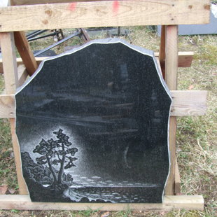 56. Granīta piemineklis ar koku un jūras ainu